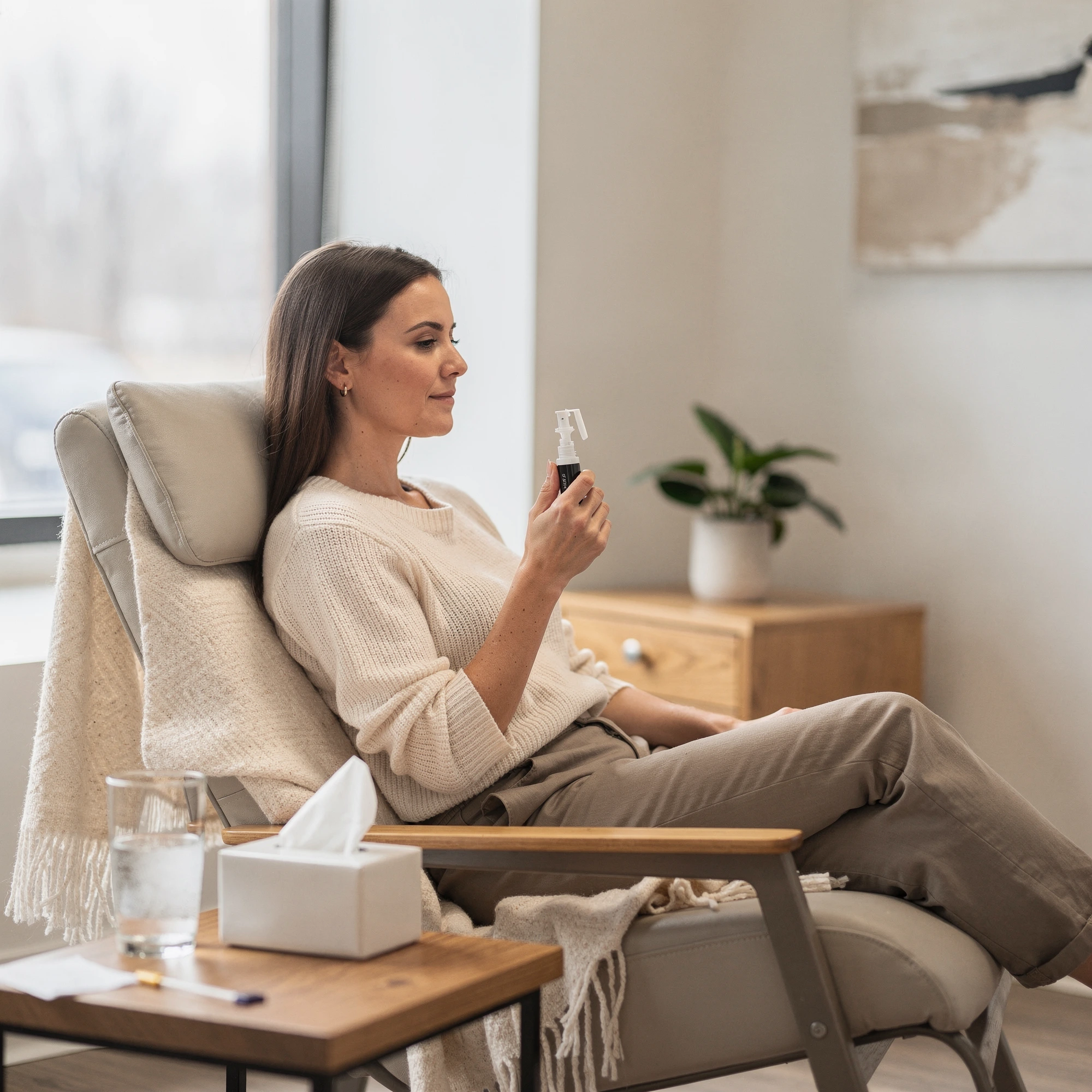 Patient seated in a comfortable chair using a nasal spray device during Spravato treatment at Myndful Wellness